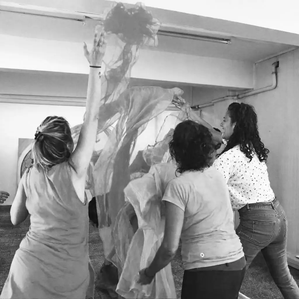 gruppo di donne felici che lanciano in aria dei tessuti